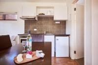 a kitchen with a table with a bottle of wine and glasses at Lorne Foreshore Caravan Park in Lorne