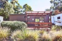 a purple tiny house with a porch and a trailer at Lorne Foreshore Caravan Park in Lorne