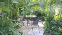 a patio with a table and chairs in a garden at Cinco Hotel B&B in San Salvador