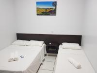 two beds in a room with a picture on the wall at New Center Hotel in Carolina