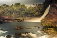 a waterfall in the jungle with a body of water at New Center Hotel in Carolina