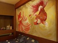 a painting of two peacocks on the wall of a bedroom at Beautifl Sweet Warm B&amp;B in Hualien City