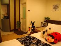 a bedroom with stuffed animals sitting on a bed at Beautifl Sweet Warm B&amp;B in Hualien City
