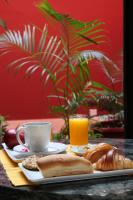 Una mesa con un plato de pan y una taza de jugo de naranja. en Hotel VDN by Good Rade, en Dakar