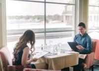 a man and a woman sitting at a table with a laptop at Rawley Resort, Spa & Marina in Port Severn