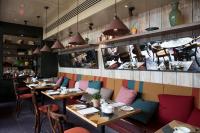 a restaurant with wooden tables and chairs and a counter at The Bull and Townhouse, Beaumaris- The Inn Collection Group in Beaumaris