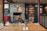 a table in a restaurant with a stone fireplace at The Bull and Townhouse, Beaumaris- The Inn Collection Group in Beaumaris