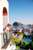 a woman standing on a balcony with a gun at Hotel Ulisse in Ischia