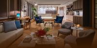a living room with a couch and chairs and a table at Just Enjoy Business Hotel in Tainan