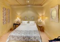 a bedroom with a white bed and a mirror at Sacristia de Santa Ana in Seville