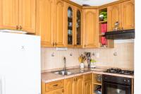 a kitchen with wooden cabinets and a sink at Stipica Apartment in Lumbarda