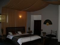 a bedroom with two beds and a canopy at Le Prieuré des Sources in La Répara