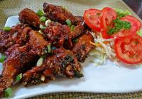 Un plato de comida con carne y tomates en una mesa. en Fairway Boutique Hotel - Kampala, Uganda, en Kampala