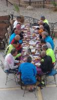 un grupo de personas sentadas en una mesa larga comiendo en Hotel Baddou, en Tamtetoucht