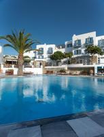 Una gran piscina con palmera y edificios. en Poseidon Hotel Suites, en Mykonos ciudad