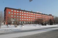 un gran edificio rojo en la nieve frente a una calle en Semey Hotel, en Semey