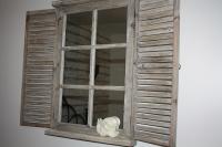 a wooden window with a white flower on a table at La Villa d&#39;Olivène in Cuers