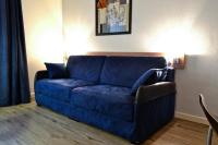 a blue couch sitting in a living room at Art Hotel Paris Est in Pantin
