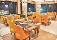 een restaurant met houten tafels en gele stoelen bij Hotel Rk Grand in Varanasi