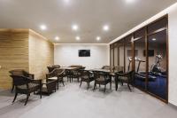 a dining room with tables and chairs and a wall at Renion Park Hotel in Almaty