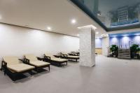 a waiting room with tables and chairs in a building at Renion Park Hotel in Almaty