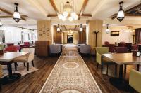 a restaurant with tables and chairs and a rug at Renion Park Hotel in Almaty
