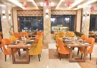 twee foto's van een restaurant met tafels en stoelen bij Hotel Rk Grand in Varanasi