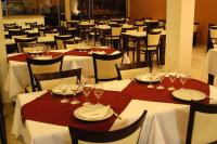 Un comedor con mesas y sillas con copas de vino. en Nuevo Mundo, en San Rafael