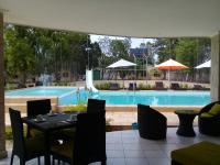 a patio with a table and chairs next to a pool at Holidays Hotel in Mahajanga