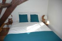 a bed with blue and white sheets and blue pillows at appartement à Colmar in Colmar