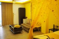 a living room with a bed and a yellow curtain at Shengtuolini B&amp;B in Yanliau