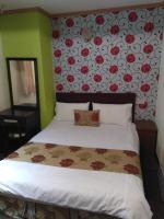 a bedroom with a bed with red flowers on the wall at Fengmao Hotel in Hualien City