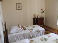 a bedroom with two beds and a dresser at Gite chez Cyrano in Bergerac