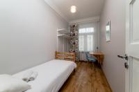 a bedroom with a white bed and a desk at Orange Cat Rooms in Riga