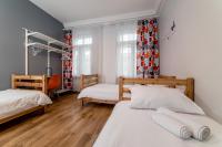 a bedroom with two beds and a desk in it at Orange Cat Rooms in Riga