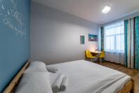 a bedroom with a bed and a table with yellow chairs at Orange Cat Rooms in Riga