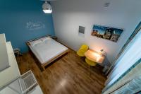 a small bedroom with a bed and a table and yellow chairs at Orange Cat Rooms in Riga