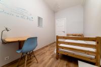 a bedroom with a bed and a desk and a chair at Orange Cat Rooms in Riga