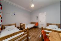 a room with two beds and a table and chairs at Orange Cat Rooms in Riga