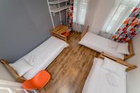 a small room with two beds and a chair at Orange Cat Rooms in Riga