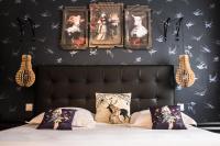 a bedroom with a bed with pictures on the wall at Hôtel Mademoiselle in Juan-les-Pins