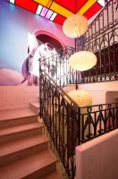a staircase with chandeliers and a painting on the wall at Hôtel Mademoiselle in Juan-les-Pins