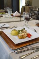 a plate of food on a table with wine glasses at Isabella Boutique Hotel in San Pedro Sula