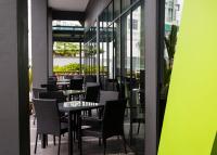 a dining room with tables and chairs and windows at 56 Hotel in Kuching