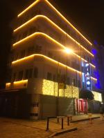 a building with lights on the side of it at night at Piano Hotel in İzmir