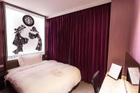 a hotel room with a bed and red curtains at The Tree House in Kaohsiung