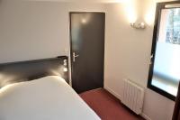 a room with a bed and a black door at The Originals City, Hôtel Amys, Tarbes Sud (Inter-Hotel) in Odos