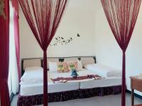 a bedroom with a canopy bed with red drapes at Rice Countryside in Dongshan