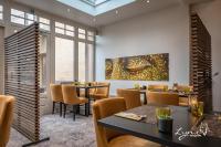 a dining room with tables and chairs and a painting on the wall at De Vesten Comfort Lodge in Laakdal