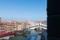 a bridge over a river in a city with boats at Palazzo Bembo - Exclusive Accommodation in Venice